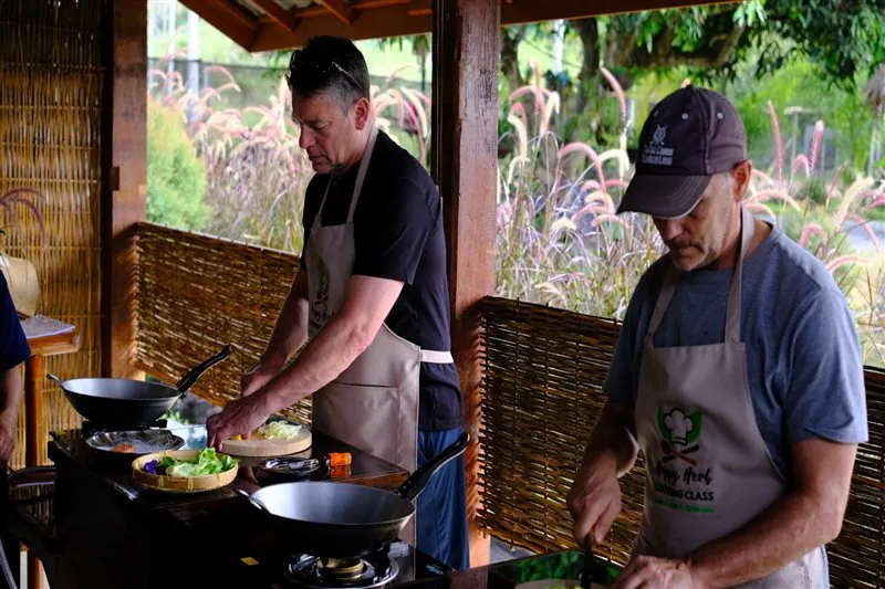 Two students learning how to cook with a wok