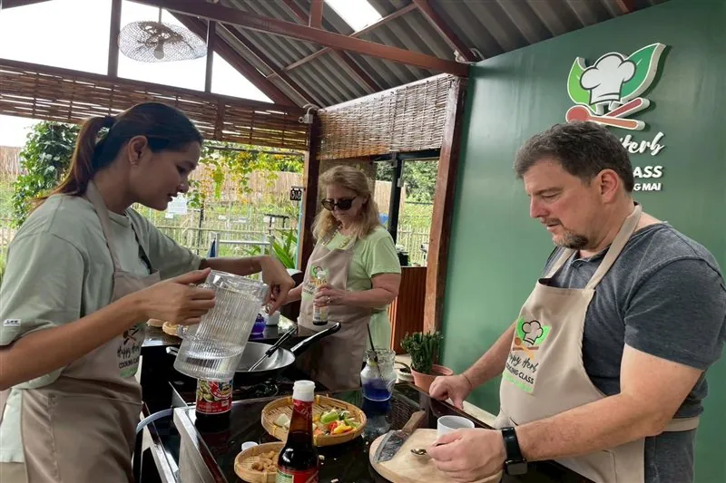 Guests cooking at individual stations in the garden kitchen