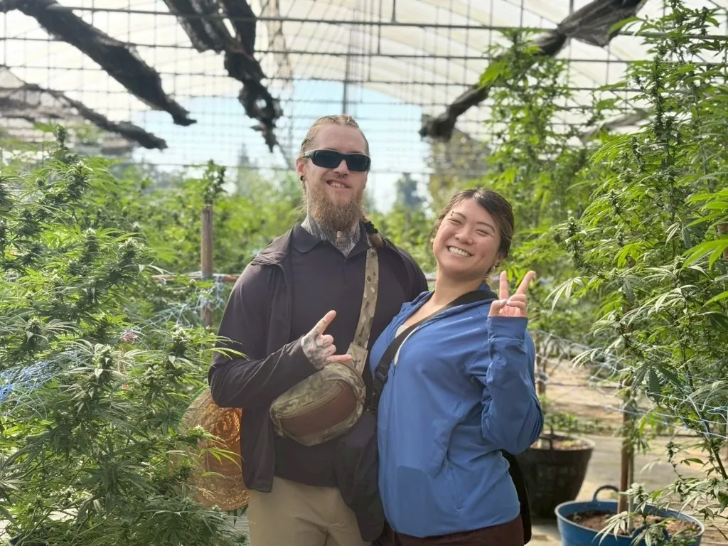 Visitors posing with their Happy Herb cannabis farm guide