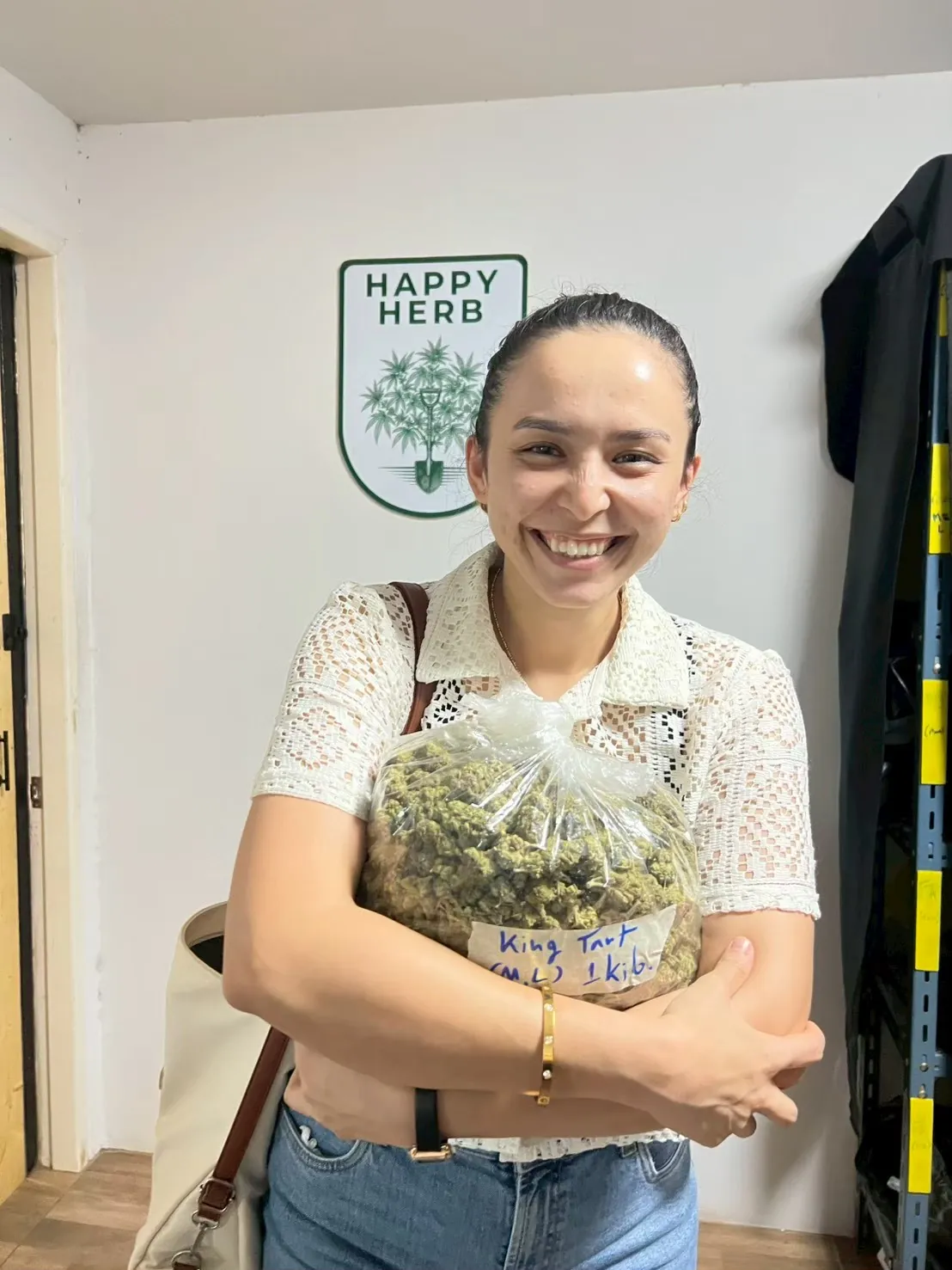 Guest smiling while holding a bag of cannabis flowers