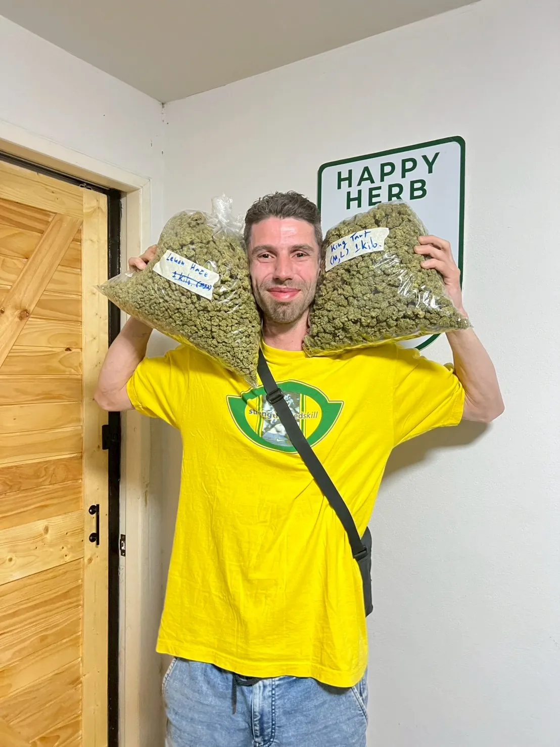 Visitor proudly holding two bags of cannabis flowers