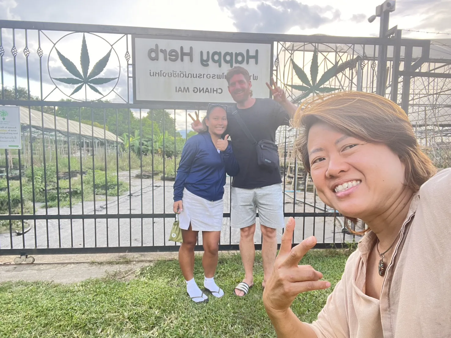 Visitors taking a welcome photo at the Happy Herb farm gate